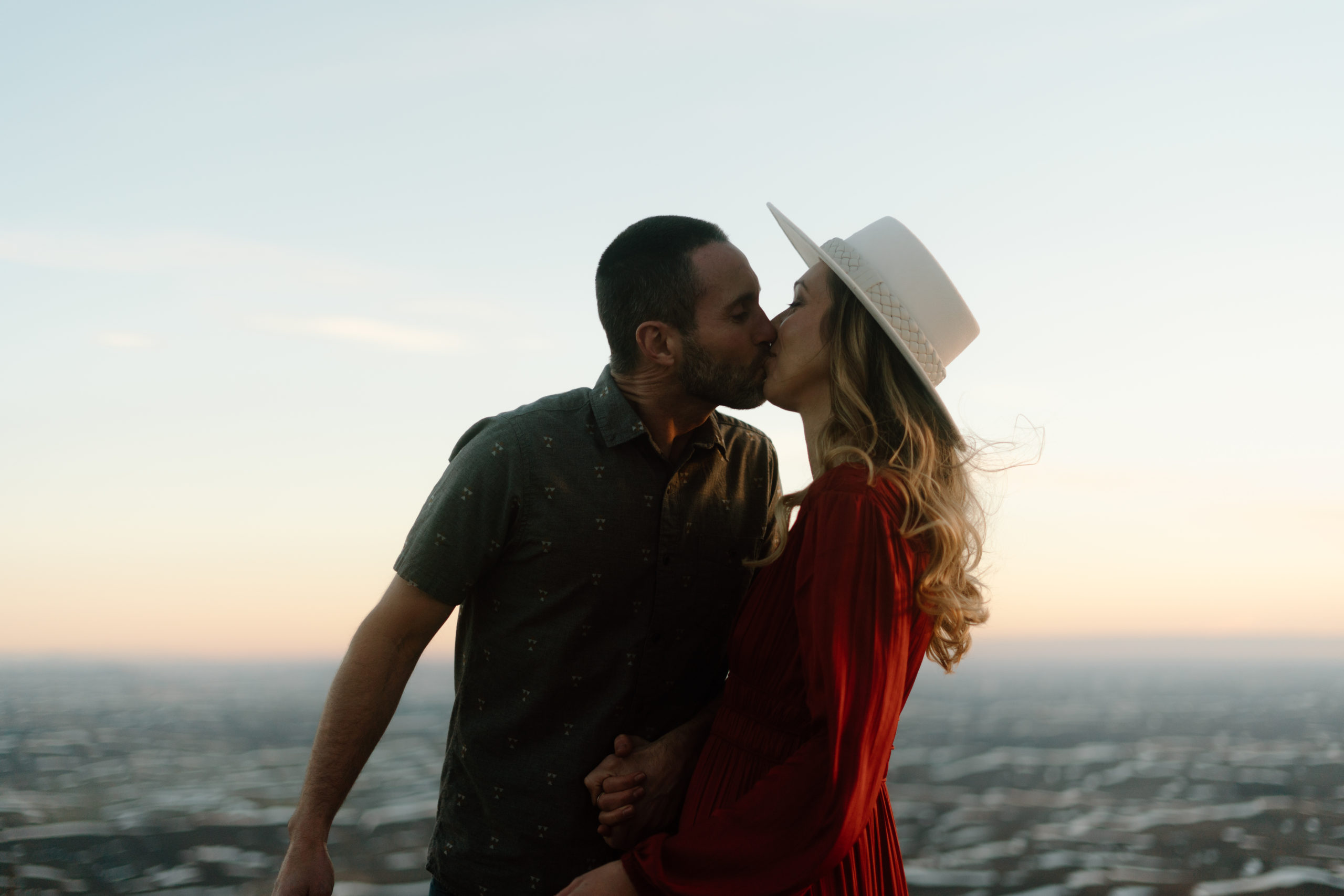 Two lovers embracing at what feels like the top of the world