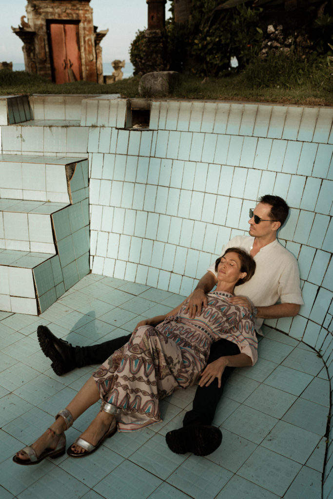 bride and groom sitting in abandoned pool at their bali elopement