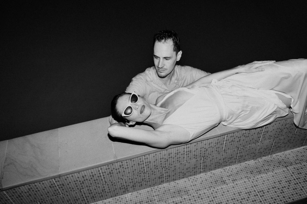 bride and groom laying near pool at bali elopement