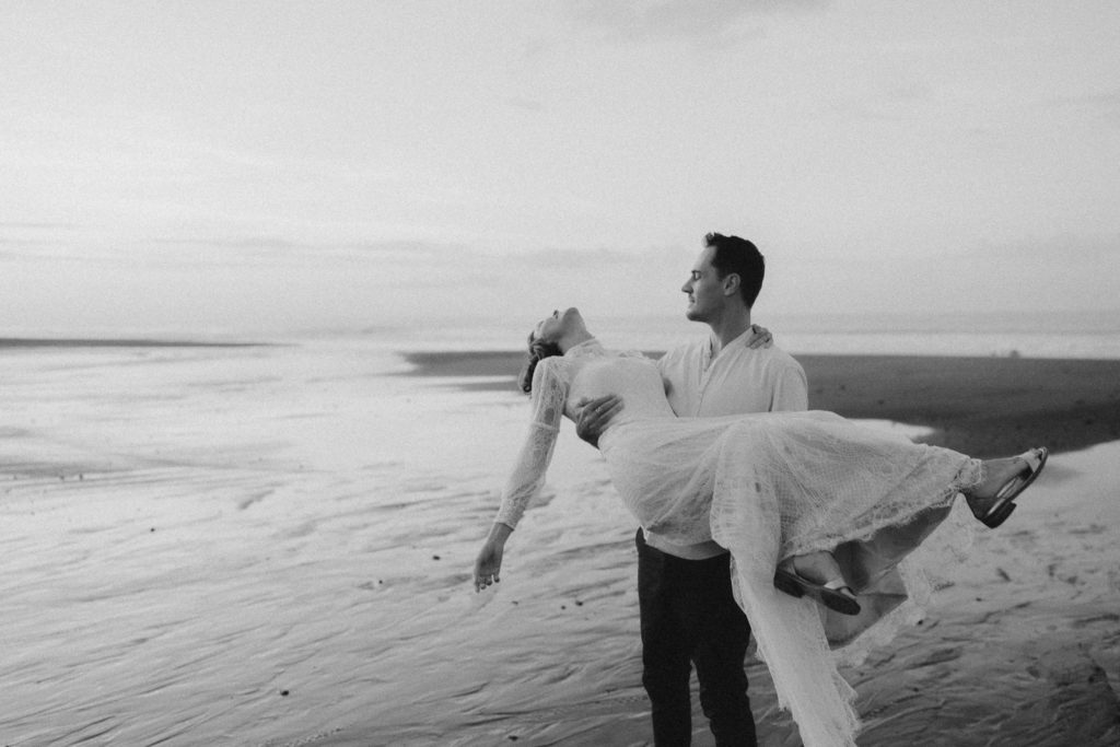 groom holding bride and spinning on the beach at their bali elopement