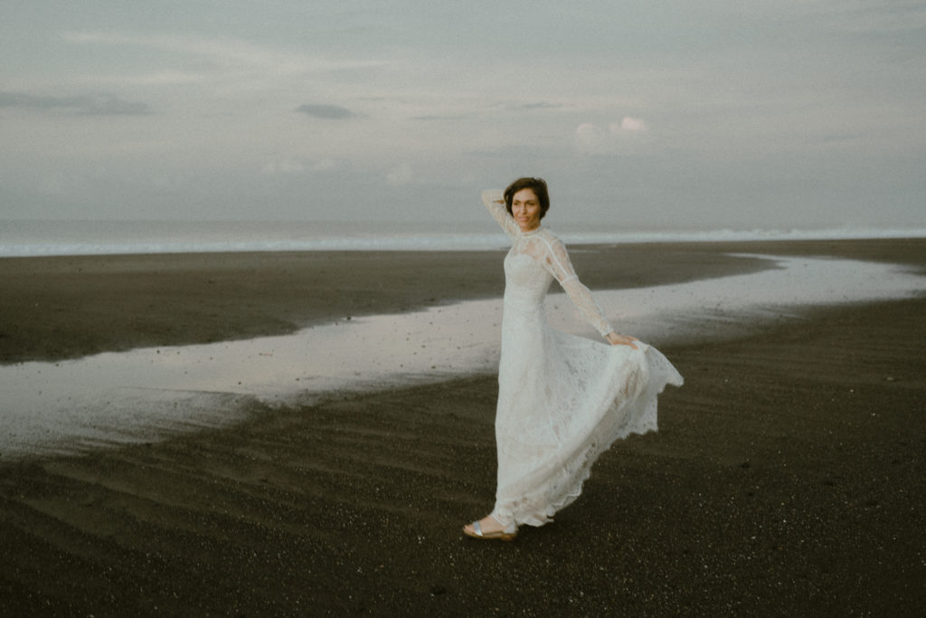 bride holding dress in the wind at her bali elopement