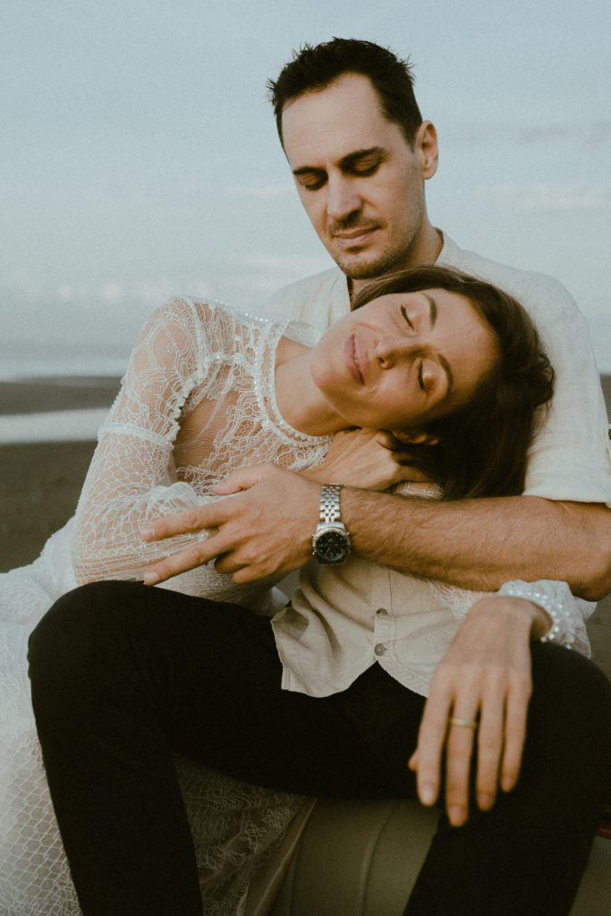 groom holding bride in his lap at their bali elopement