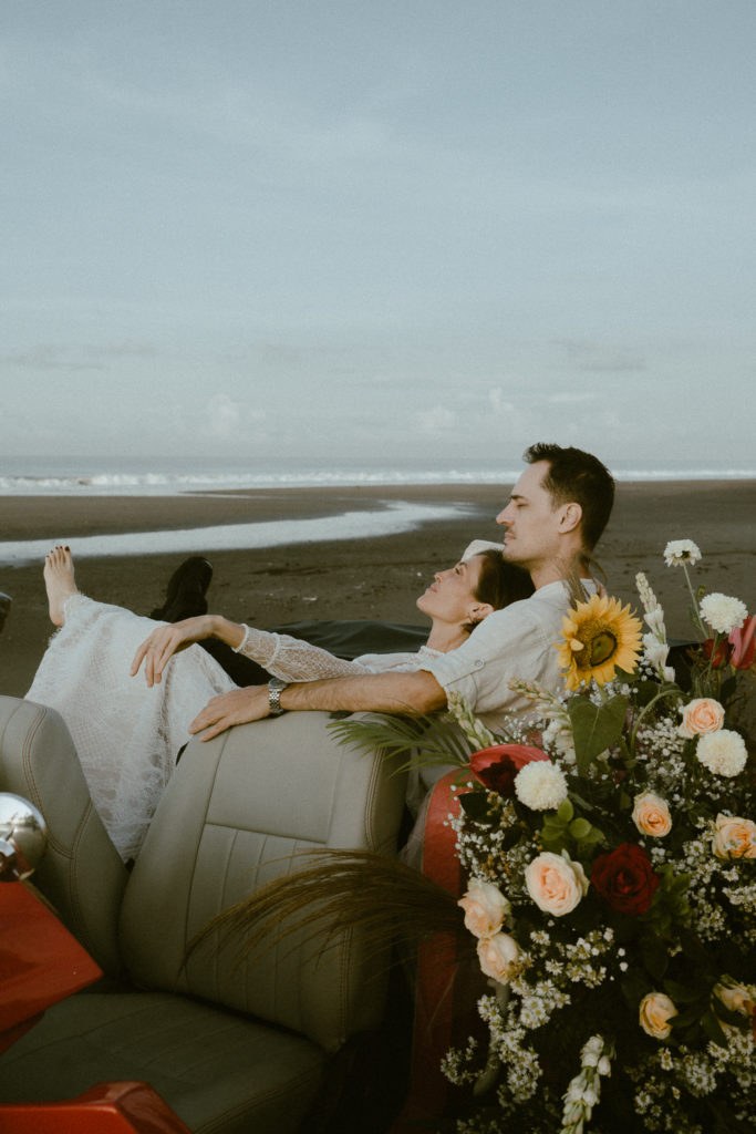 couple cuddling on vintage convertible at their bali elopement