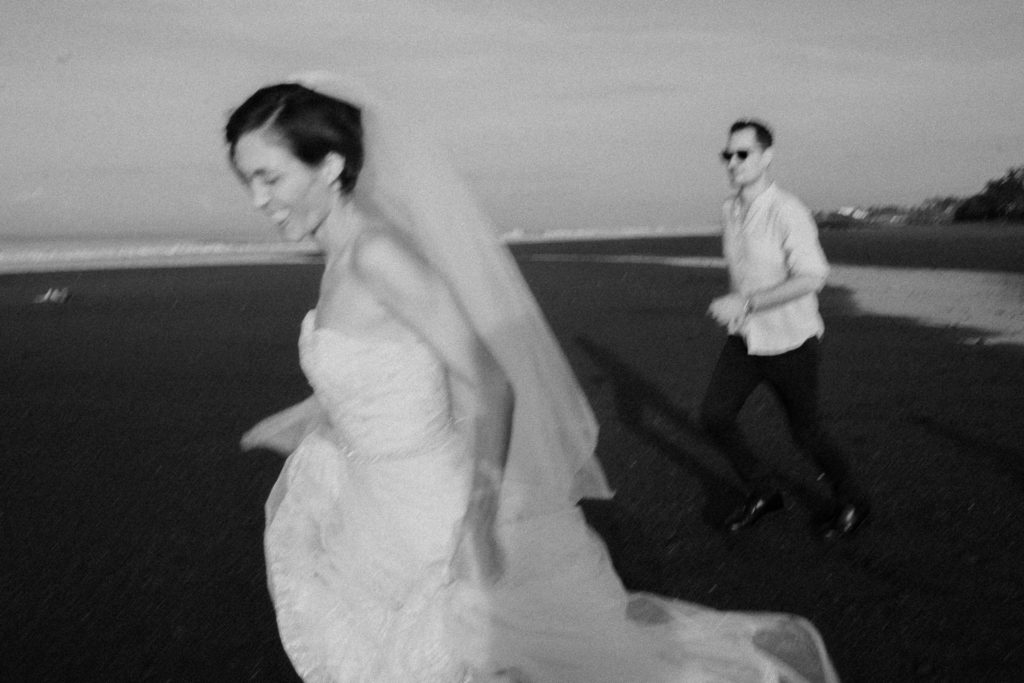 bride and groom running on the beach at their bali elopement