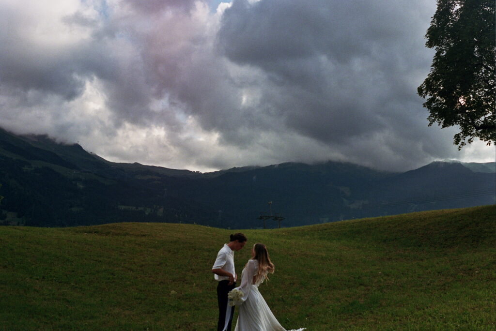 bride and groom standing next to each other with the swiss alps in the background at their switzerland elopement