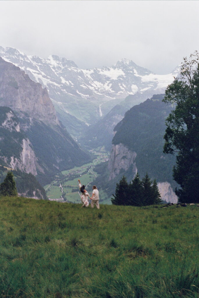 couple holding hands with the swiss alps in the background at their switzerland elopement