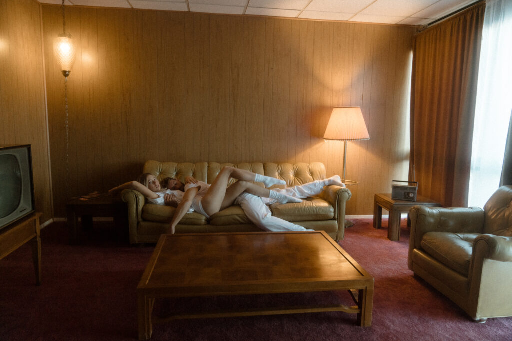 couple cuddling on a retro couch at their portland engagement photo session